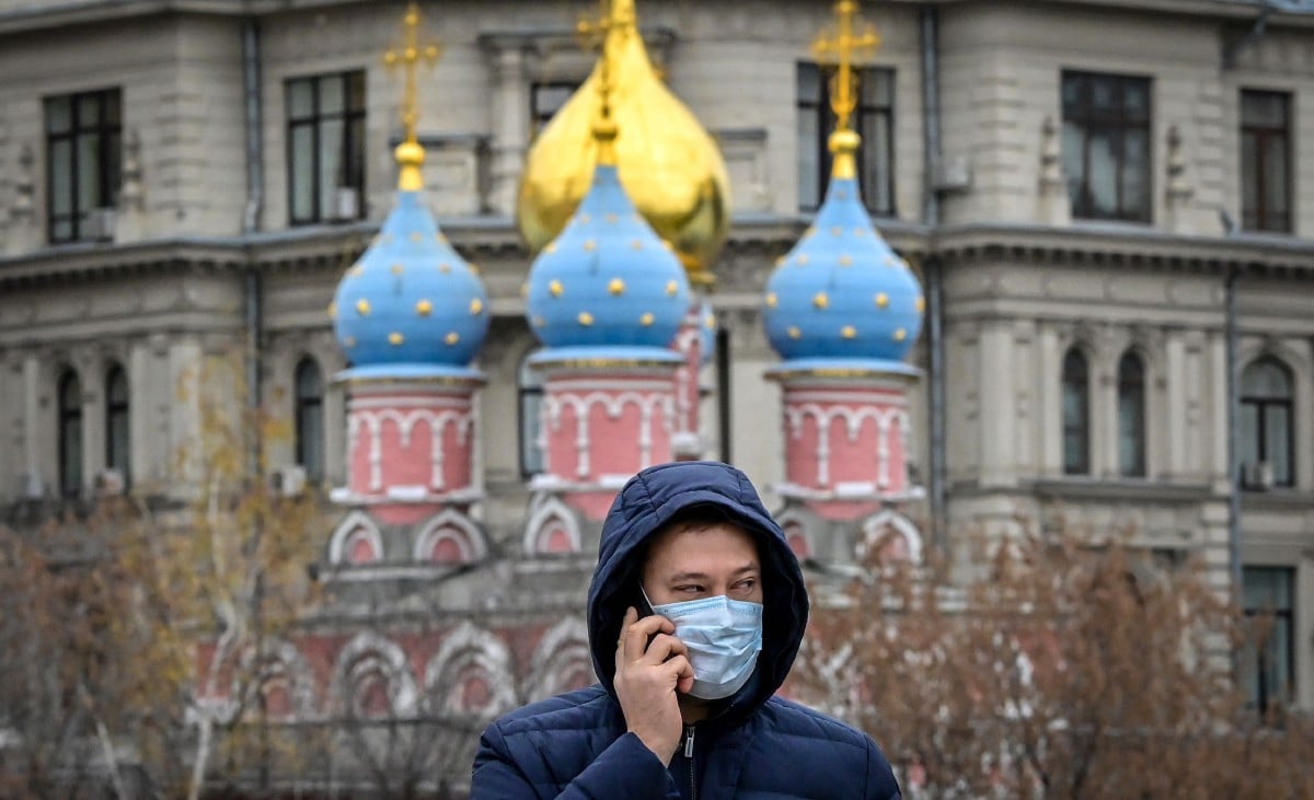 Seorang lelaki memakai pelitup muka berjalan di pusat bandar Moscow. Rusia antara negara di Eropah paling terjejas akibat Covid-19 dengan angka kematian harian melebihi 1,000. - FOTO AFP