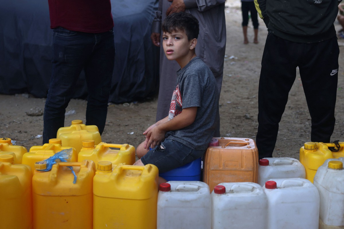 Kanak-kanak Palestin menunggu giliran untuk mendapatkan bekalan air bersih. - FOTO AFP