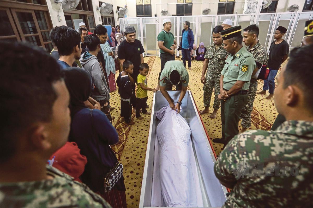 ANGGOTA ATM membantu menguruskan Jenazah Sarjan Rozali Abdull Rani yang maut dalam nahas kemalangan Lebuhraya Utara Selatan untuk disembahnyang di Masjid Gong Bayor. FOTO Ghazali Kori