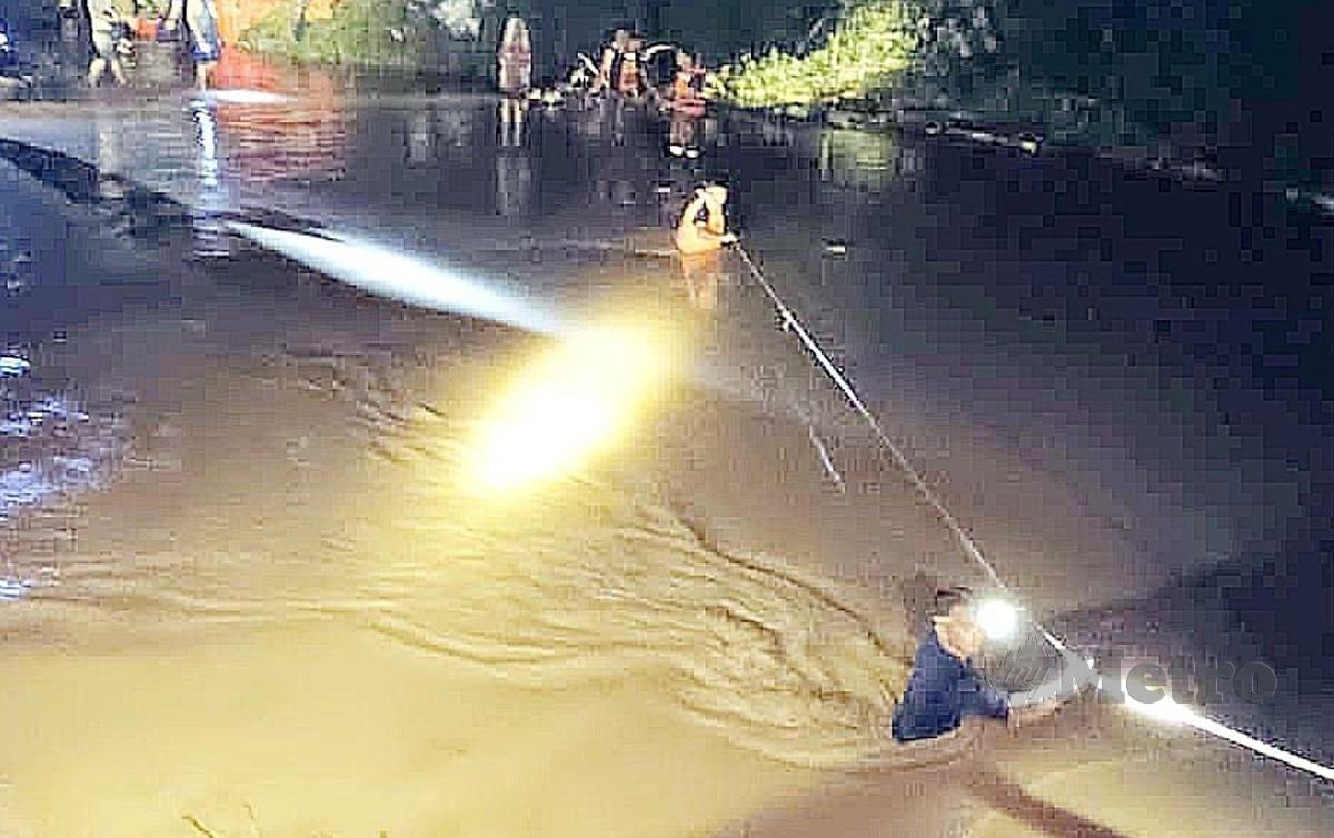 PASUKAN penyelamat menggunakan 'safety line' untuk membawa mangsa menyeberangi sungai. FOTO Melvin Joni