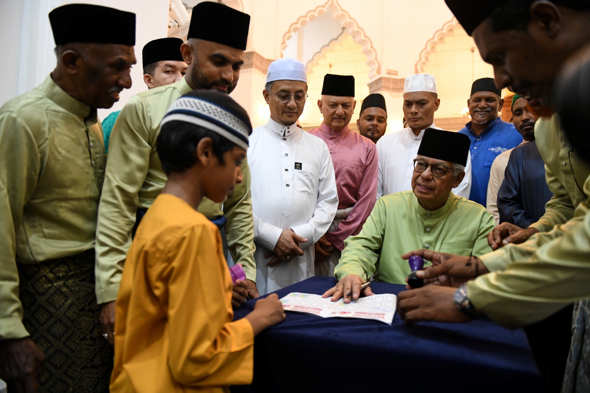 FUZI Abdul Razak menandatangani buku khas Program Didik Kanak-kanak untuk jemaah cilik sempena Ramadan selepas selesai solat tarawih. FOTO Bernama