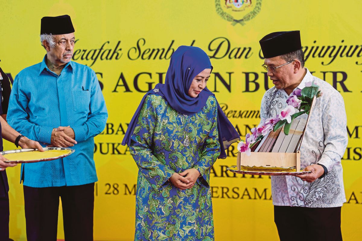 RAJA Zarith Sofiah (tengah) berkenan menerima cenderamata daripada (JAWI) Datuk Mohd Ajib Ismail (kanan) pada Majlis Agihan Bubur Lambuk FOTO Bernama
