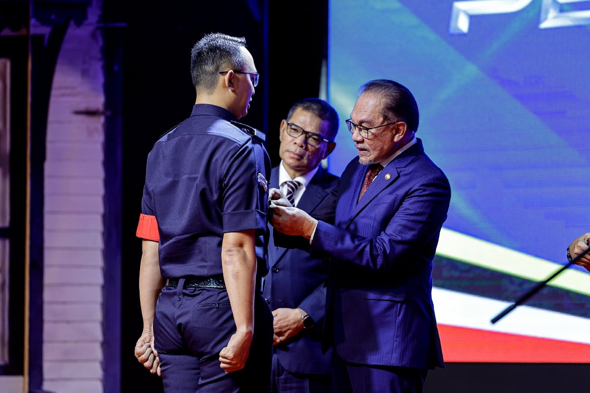 ANWAR Ibrahim (kanan) memakaikan pingat Anugerah Juara Integriti kepada penerima pada sambutan Peringatan Hari Polis Ke-217 di Pusat Latihan Polis (PULAPOL) Kuala Lumpur hari ini. FOTO Bernama