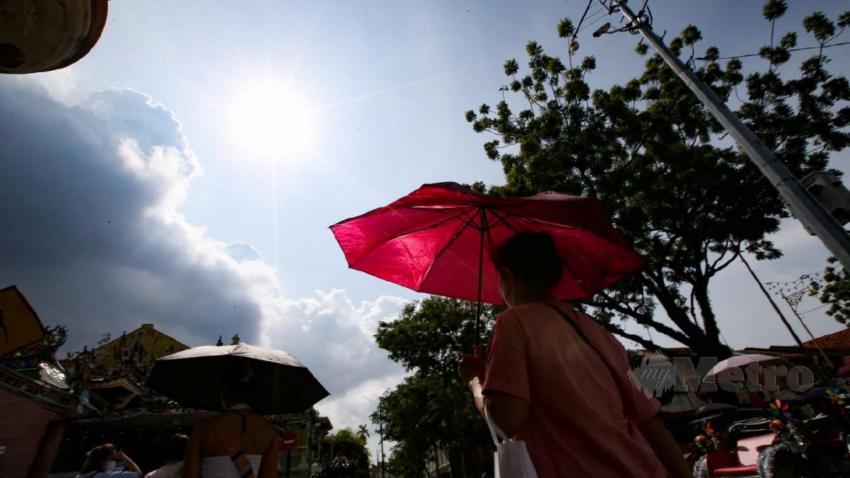 GAMBAR hiasan/Orang awam menggunakan payung bagi melindungi diri daripada cuaca panas ketika tinjauan di Tapak Warisan Dunia UNESCO, Lebuh Armenian, Pulau Pinang hari ini. FOTO MIKAIL ONG