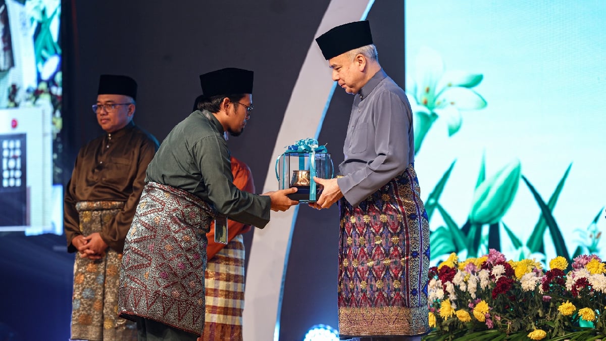SULTAN Perak Sultan Nazrin Shah berkenan menyampaikan hadiah peserta terbaik Tilawah kepada Mohd Kamaruzaman. FOTO BERNAMA