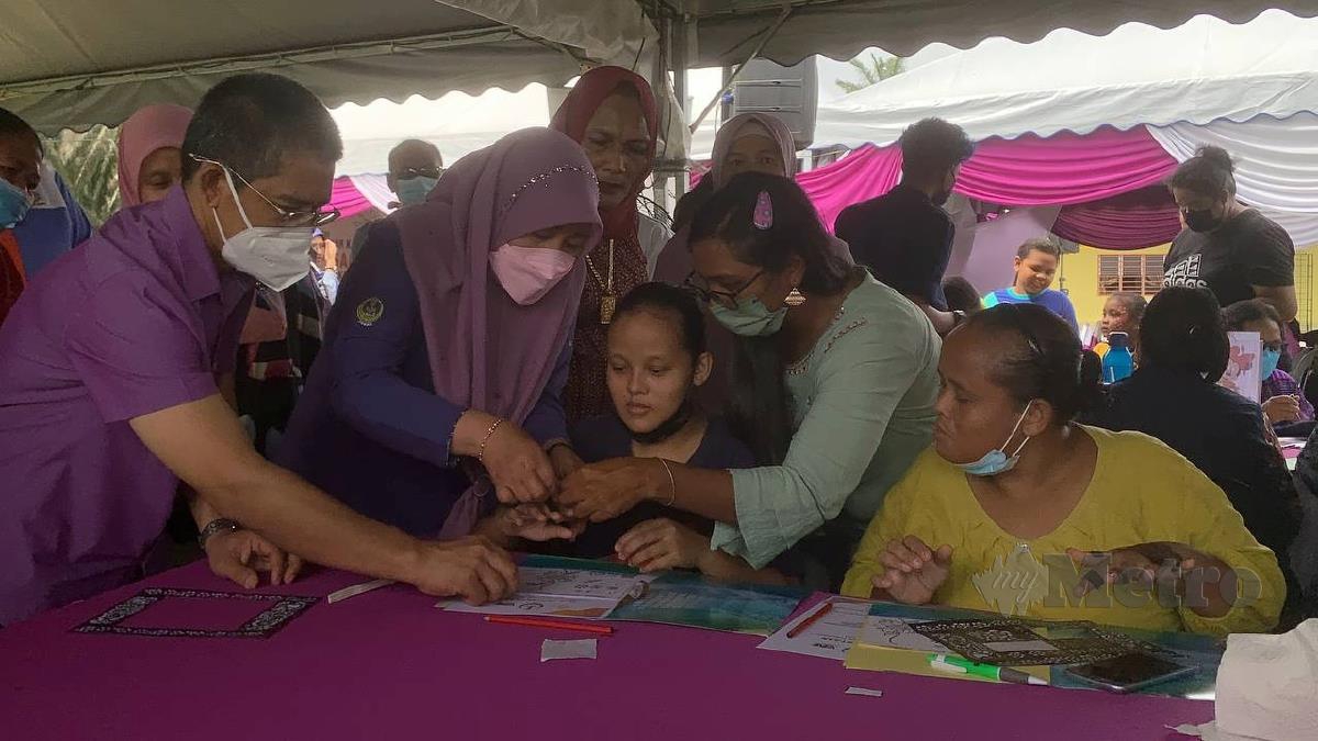 DATUK Dr Wan Norashikin Wan Noordin (dua kiri) beramah mesra dengan komuniti Orang Asli pada program Jelajah Kasih Keluarga Malaysia di Padang Kampung Chenderong Kelubi, Kampung Gajah, Pasir Salak. FOTO NOOR HIDAYAH TANZIZI.