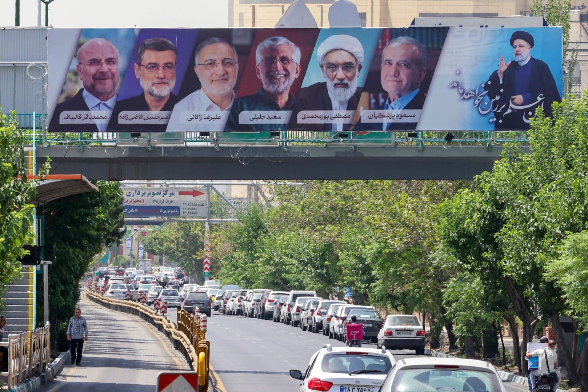 Papan iklan memaparkan wajah calon presiden baharu Iran. - FOTO AFP