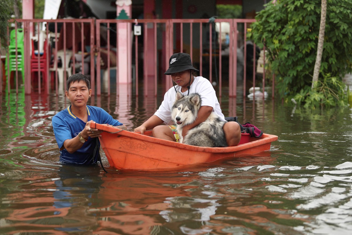 Penduduk setempat menyelamatkan diri selepas kediaman mereka ditenggelami air di wilayah Ubon Ratchathani, Thailand. - FOTO AP