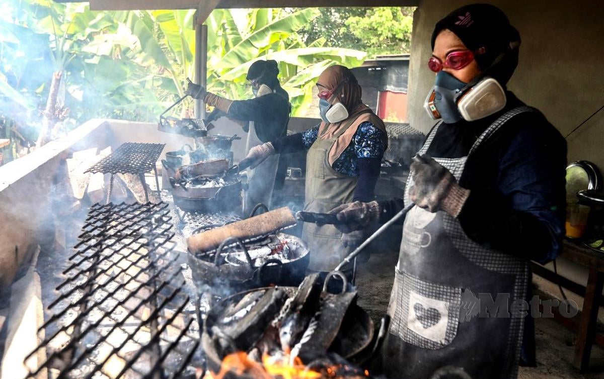 PEKERJA memakai topeng ketika proses membakar adunan kuih tradisional di Kampung Padang Tengir, Manir. FOTO Ghazali Kori