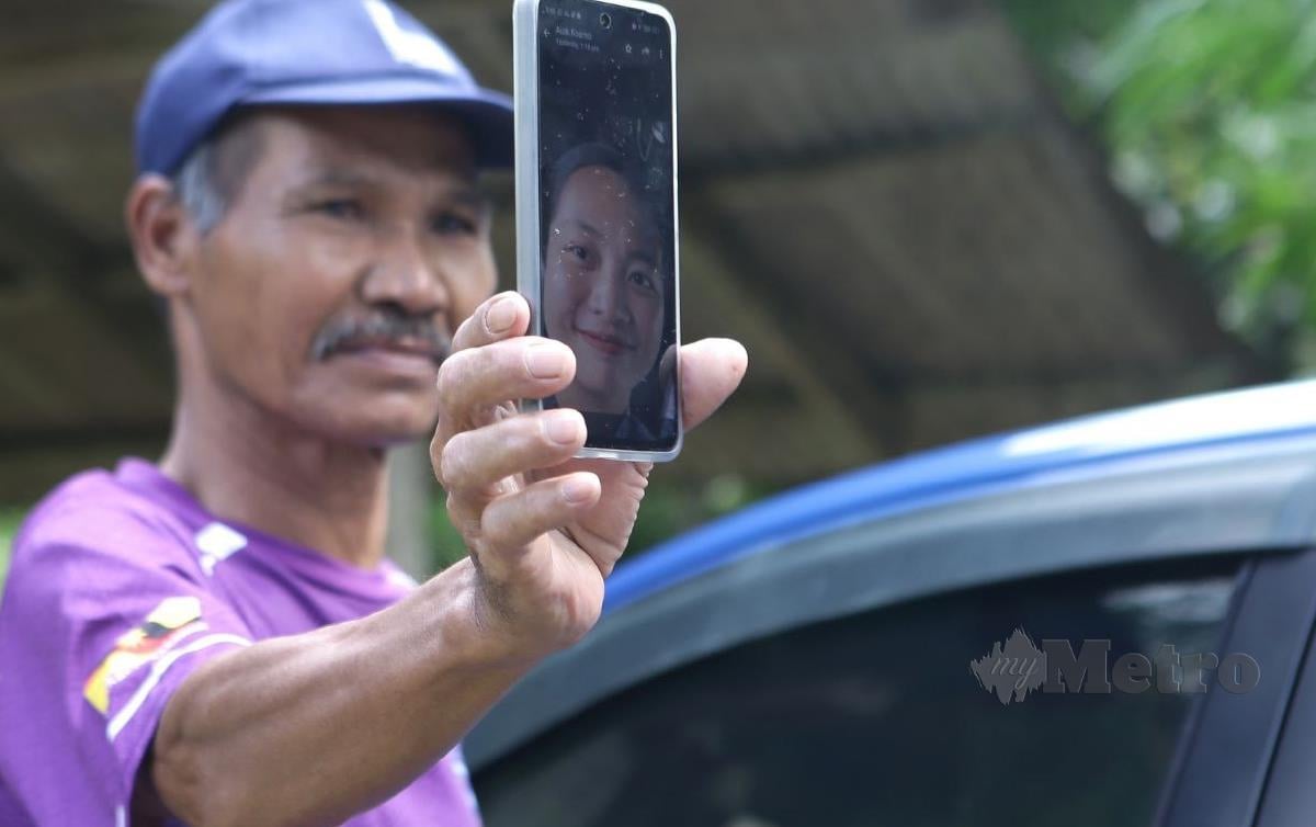 BAPA saudara Bateh Mangkok menunjukan gambar mendiang yang terkorban dalam Nahas Helikopte di Tanah Perkuburan Kampung Engkaroh Tebekang. FOTO Nadim Bokhari