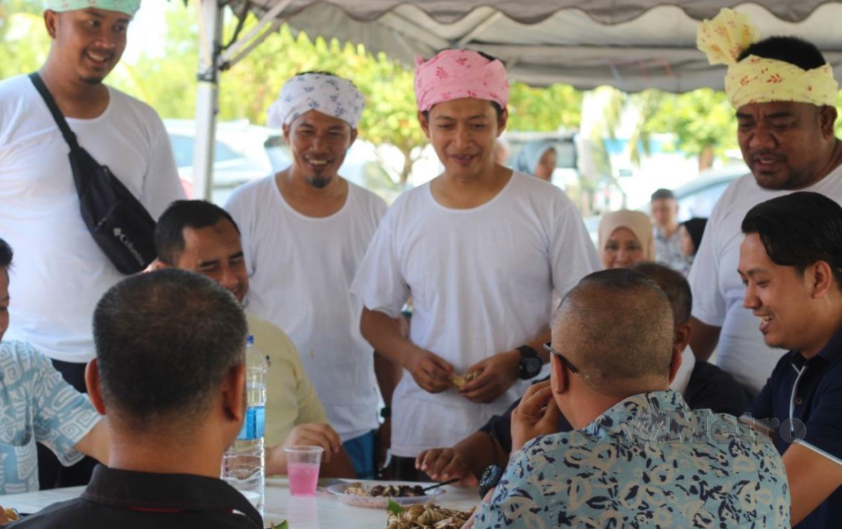KHAIRUL (tengah) ketika melayani tetamu sempena Rumah Terbuka Aidilfitri Pejabat Laut Tok Bali di Tok Bali, Pasir Puteh. FOTO Nor Amalina Alias