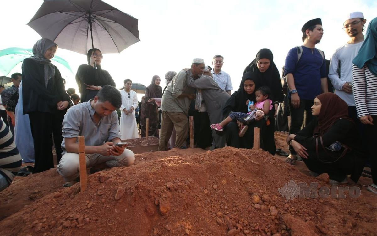 ADELIA Citra Hapsari bersama anak bongsunya selepas selesai kebumi jenazah suaminya, penyanyi, Nabil Zamanhuri di tanah perkuburan Islam Ukay Perdana. FOTO Eizairi Shamsudin
