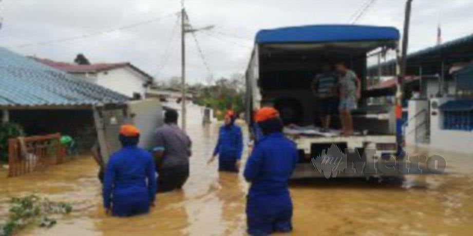 ANGGOTA APM membantu penduduk memindahkan barang ketika banjir kilat lewat petang tadi. FOTO ihsan APM