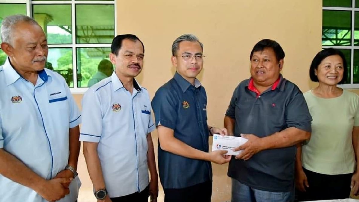 Menteri Komunikasi dan Digital, Fahmi Fadzil (tengah) menyerahkan sumbangan Tabung Kasih @ HAWANA kepada bekas Ketua Bahagian Editorial NST Sabah dan Sarawak, Joseph Bingkasan di Kota Kinabalu. FOTO ihsan Kementerian Komunikasi dan Digital