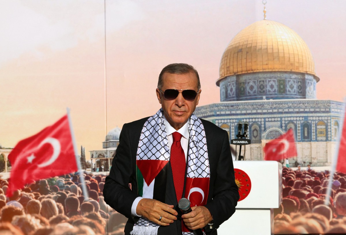 Presiden Turkiye Tayyip Erdogan, memakai selendang dengan bendera Palestin dan Turki, berdiri di atas pentas semasa perhimpunan yang dianjurkan oleh parti AKP sebagai solidariti dengan rakyat Palestin di Gaza, di Istanbul pada 28 Oktober 2023. FOTO PEJABAT AKHBAR PRESIDEN TURKIYE /AFP