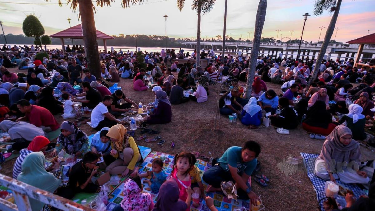 HAMPIR 1,000 pengunjung tidak melepaskan peluang bersama keluarga dan rakan untuk iftar beramai-ramai sambil menikmati pemandangan matahari terbenam di tebing Sungai Kelantan berhampiran Jambatan Sultan Yahya Petra. FOTO NIK ABDULLAH NIK OMAR