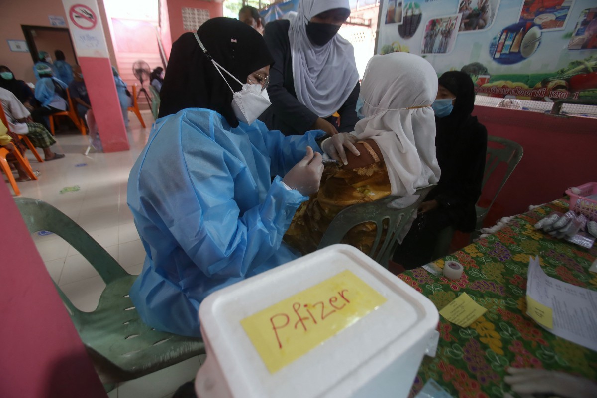 Kakitangan kesihatan memberikan suntikan vaksin Covid-19 kepada seorang wanita di Mueang, Pattani. - FOTO AFP