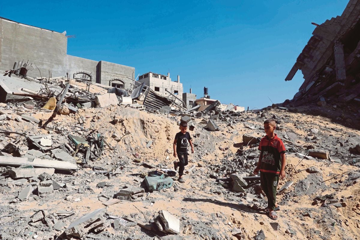 KANAK-KANAK Palestin memeriksa runtuhan bangunan yang musnah berikutan pengeboman Israel. FOTO AFP
