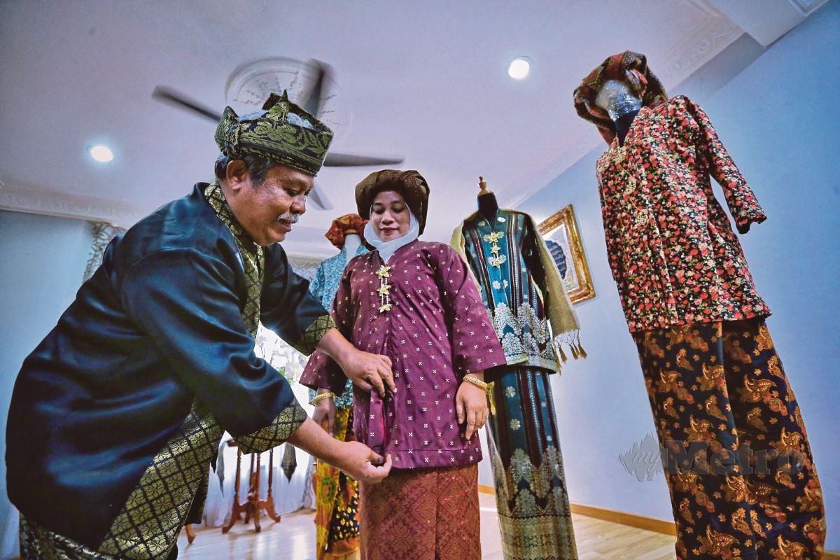 ALIAS menerangkan ciri-ciri baju Kebaya Setengah Tiang yang merupakan Busana Tradisional Negeri Sembilan ketika ditemui dikediamannya di Taman Pinggiran Golf. FOTO Azrul Edham