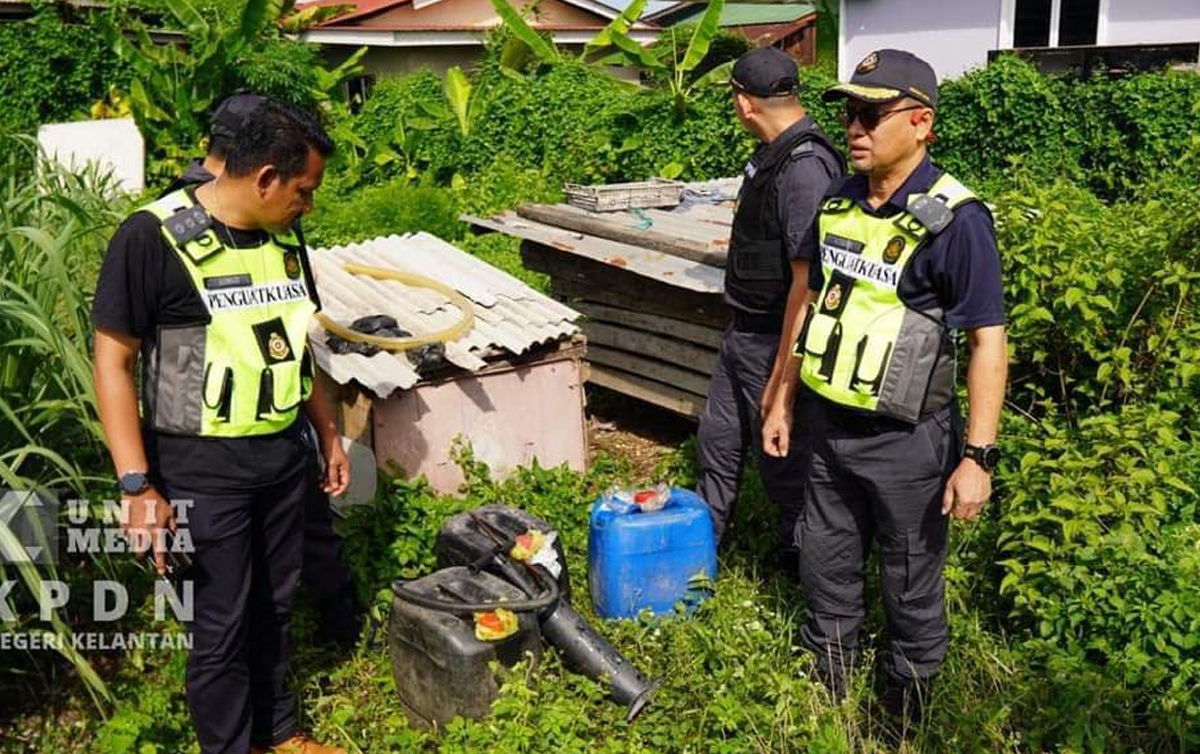Pengarah KPDN Kelantan (pakai vest dan bertopi) memeriksa lokasi transit yang dipercayai menjalankan aktiviti penyelewengan petrol. FOTO ihsan KPDN