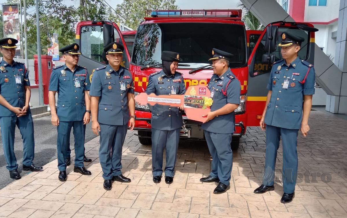 KHARIR Mat menyerahkan replika kunci CFRT kepada Ketua Balai Bomba Penyelamat Kuala Terengganu Rozizah Abnihajar. FOTO Nazdy Harun