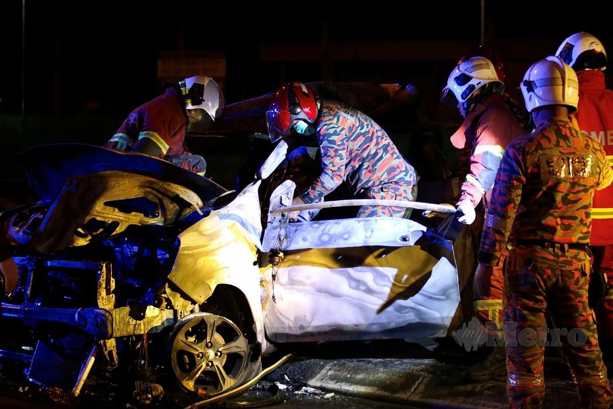 ANGGOTA bomba memadam kebakaran Perodua Axia sebelum mengeluarkan mayat dua individu yang rentung. FOTO Mohd Adam Arinin.