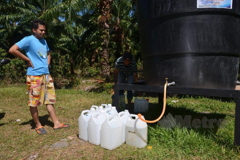 RAJA Shahrul Raja Mohamad menadah air di pusat agihan setempat SAMB di Kampung Balik Batu, Tanjung Bidara berikutan catuan air sejak 29 Januari lalu. FOTO Hassan Omar