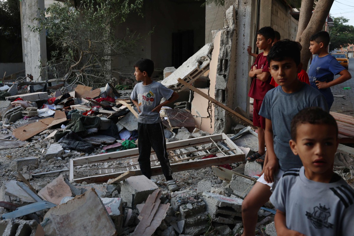 Kanak-kanak lelaki Palestin melihat runtuhan rumah yang membunuh lapan sekeluarga dalam serangan udara Israel, di Rafah di selatan Semenanjung Gaza pada 30 Oktober 2023. FOTO AFP