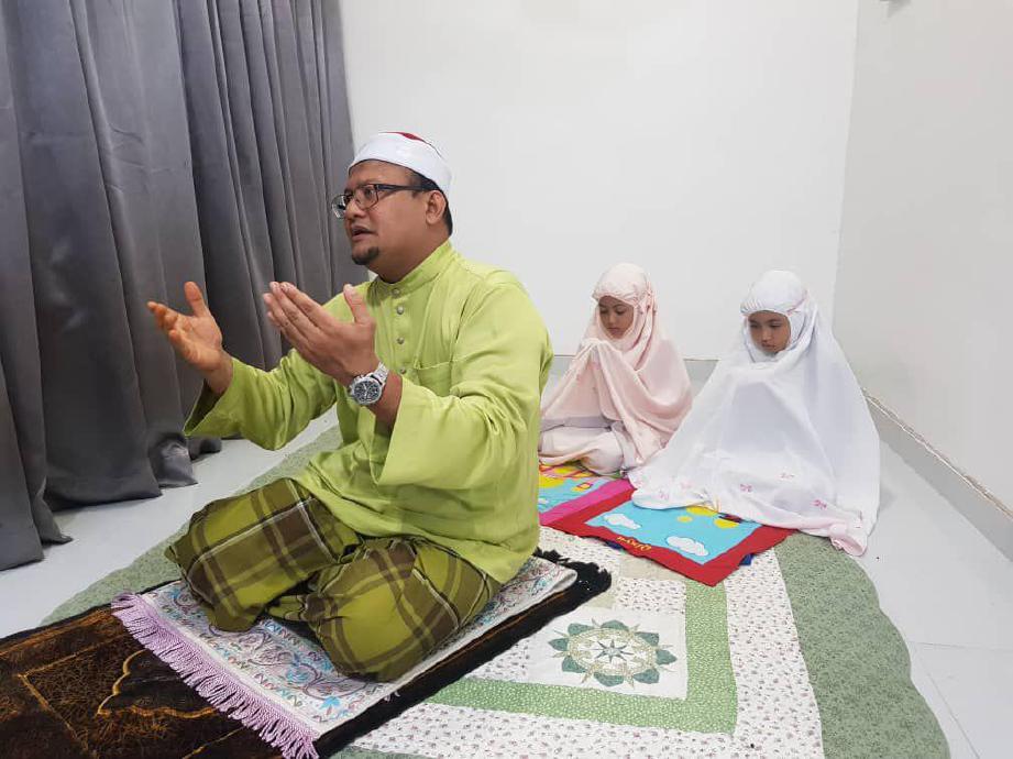 ZAKI dari Kampung Pak Jin sedang menunaikan solat sunat tarawih bersama dua anak kembarnya, Qisya dan Qaseh, 9, di rumah. FOTO ihsan Mohd Zaki Mat Yakim