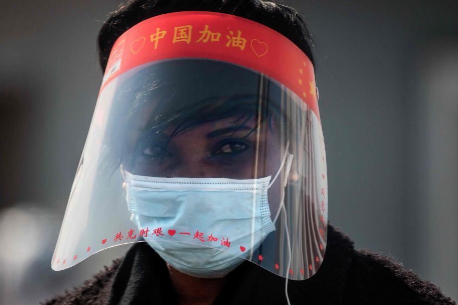 SEORANG warga China mengenakan pelitup muka. FOTO AFP
