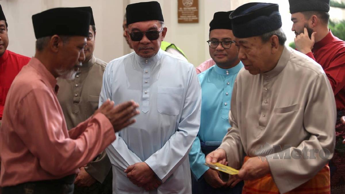 Sultan Selangor Sultan Sharafuddin Idris Shah, diiringi Perdana Menteri Datuk Seri Anwar Ibrahim, menyampaikan sumbangan kepada penerima ketika Majlis Berbuka Puasa Bersama Rakyat di Masjid Tengku Ampuan Jemaah, Bukit Jelutong, Shah Alam. FOTO MOHAMAD SHAHRIL BADRI SAALI