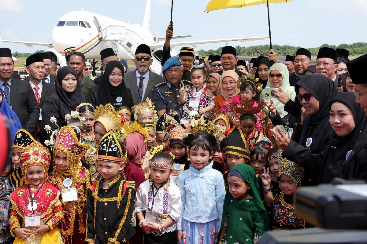 AL-SULTAN Abdullah dan Tunku Azizah berkenan mendukung kanak-kanak dari Tadika Kemas dan Perpaduan Tawau di LapanganTerbang Tawau bagi memulakan pengembaraan mendekati rakyat Sabah dan Sarawak. FOTO BERNAMA