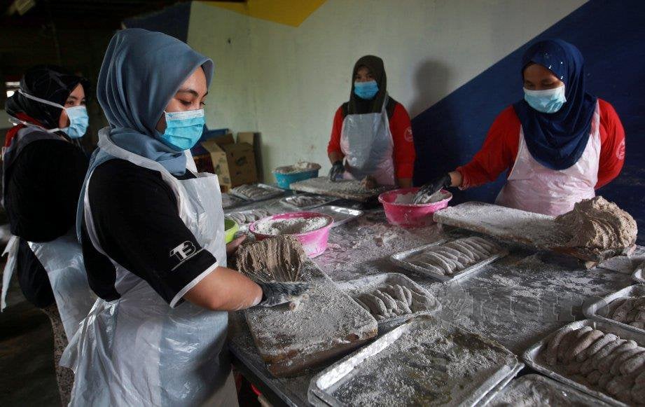  KAKITANGAN Perusahaan Keropok Tokku Lekor melakukan proses menggetel keropok untuk dijual kepada pelanggan sepanjang tempoh PKP di Kampung Losong. FOTO Ghazali Kori