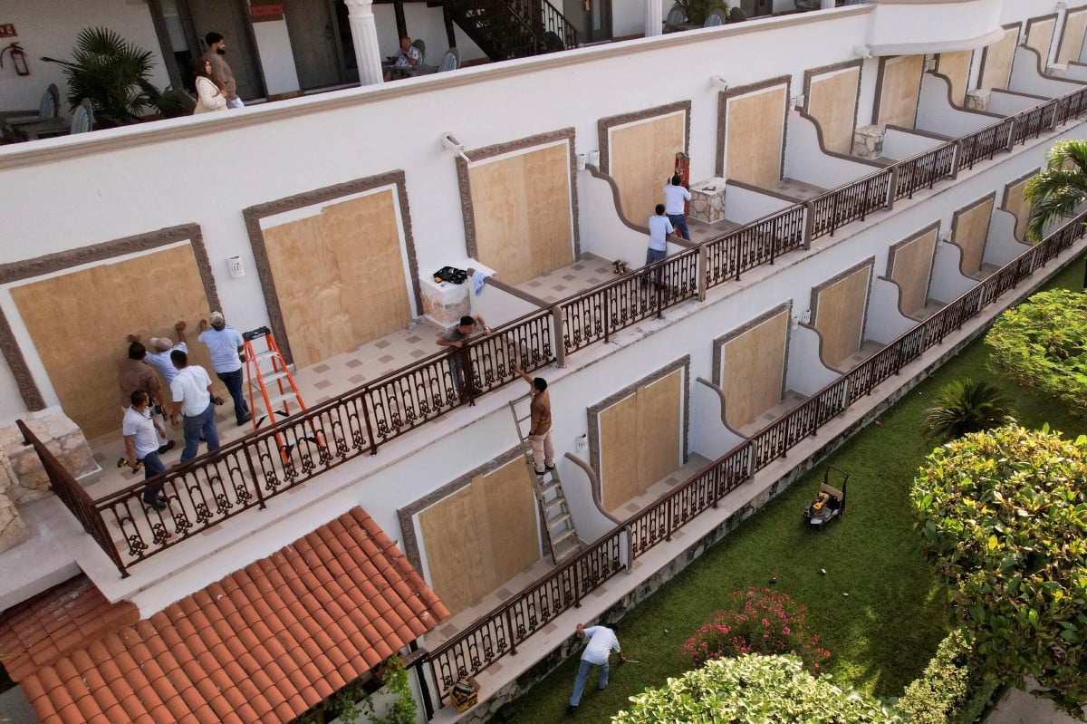 Pemandangan dron menunjukkan pekerja memasang papan kayu untuk menutup pintu kaca di sebuah hotel sebagai persiapan menjelang ketibaan Taufan Beryl, di Playa del Carmen, Mexico. FOTO REUTERS