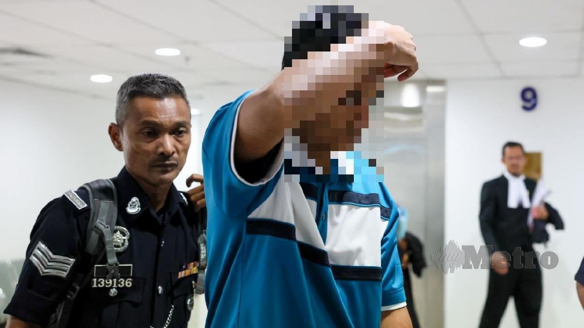 Pemandu e-hailing diiringi anggota polis ketika tiba di Mahkamah Sesyen Kuala Terengganu. Foto FAIZUL AZLAN RAZAK
