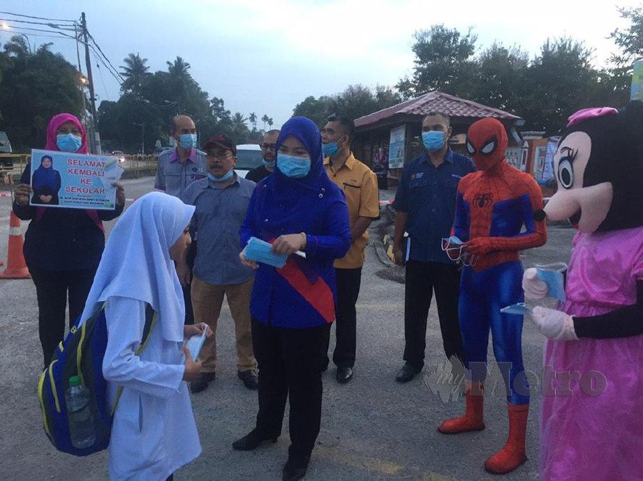 NOR Hafizah Othman bersama adiwira menyampaikan pelitup muka kepada murid Sekolah Kebangsaan (SK) Pengkalan Jaya yang memulakan sesi persekolahan hari ini. FOTO Nur Izzati Mohamad