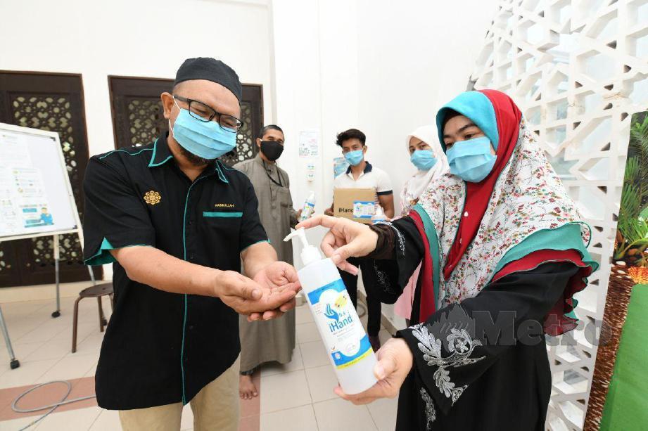 RPOF Madya Dr Farahidah Mohamed menyumbangkan pembasmi kuman (hand sanitizer) kepada Timbalan Pengarah Masjid Sultan Haji Ahmad Shah UIAM Kuantan, Dr Hasbullah Mohamad. FOTO Mohd Rafi Mamat