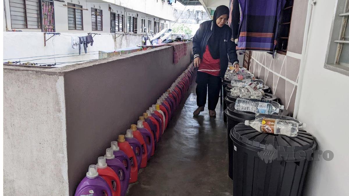 Jamaliah Yusoff menyimpan air dalam pelbagai bekas bagi menghadapi gangguan bekalan air berjadual pada Rabu ini. FOTO ZUHAINY ZULKIFFLI 