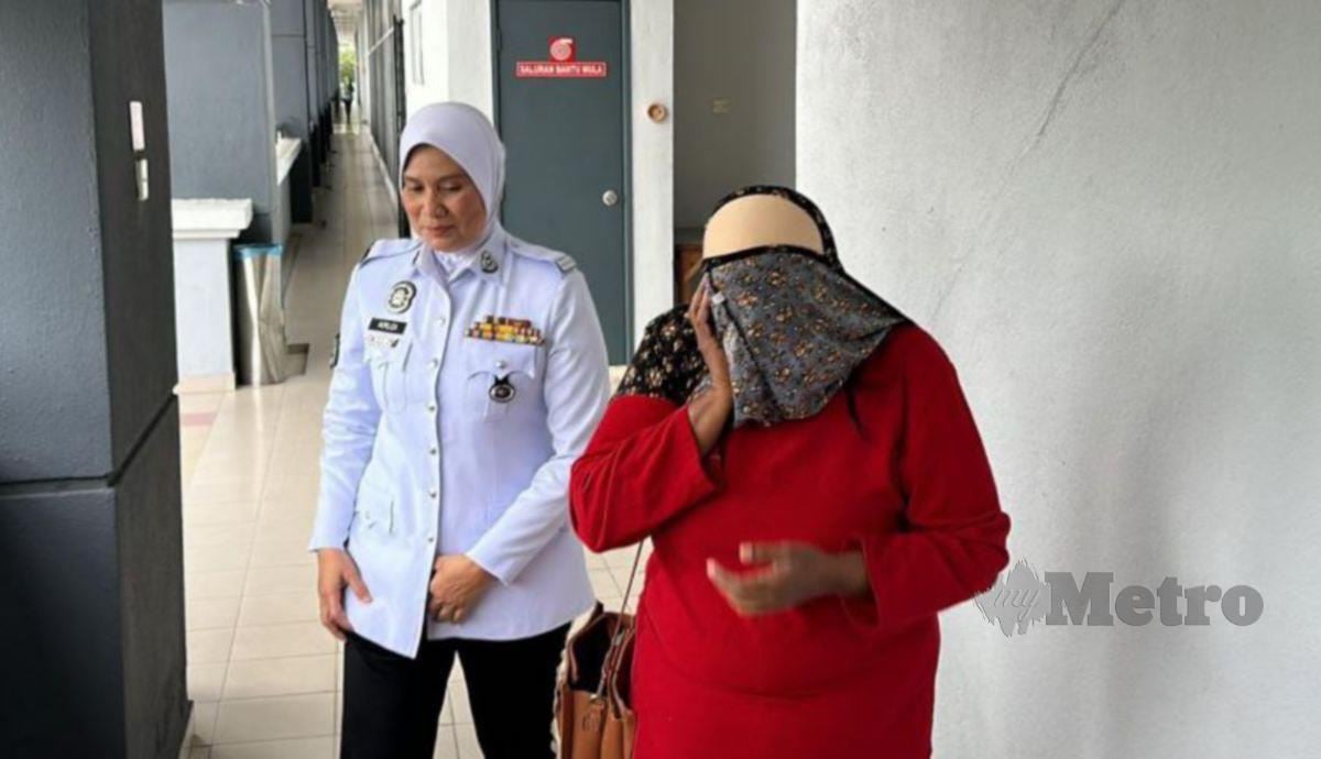 WANITA (kanan) didenda RM700 selepas bersalah membenarkan anaknya berusia 10 tahun memandu kereta. FOTO Ahmad Hasbi.