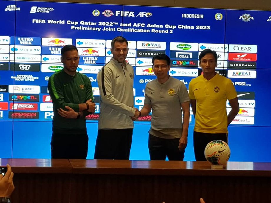 JURULATIH skuad kebangsaan, Tan Cheng Hoe bersalaman dengan pengendali Indonesia, Simon McMenemy sambil disaksikan Farizal (kanan) dan kapten skuad Garuda ketika sidang media hari ini. 