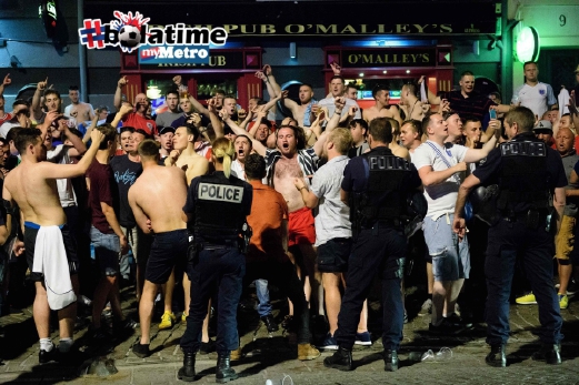 Polis mengawasi penyokong England yang berkumpul di luar sebuah pub di kawasan pelabuhan Marseille. FOTO AFP