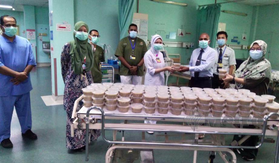 DR S Sivanandarajah (tiga kanan) menyampaikan bubur lambuk kepada kakitangan hospital di salah sebuah wad di Hospital Slim River. FOTO Rosman Shamsudin