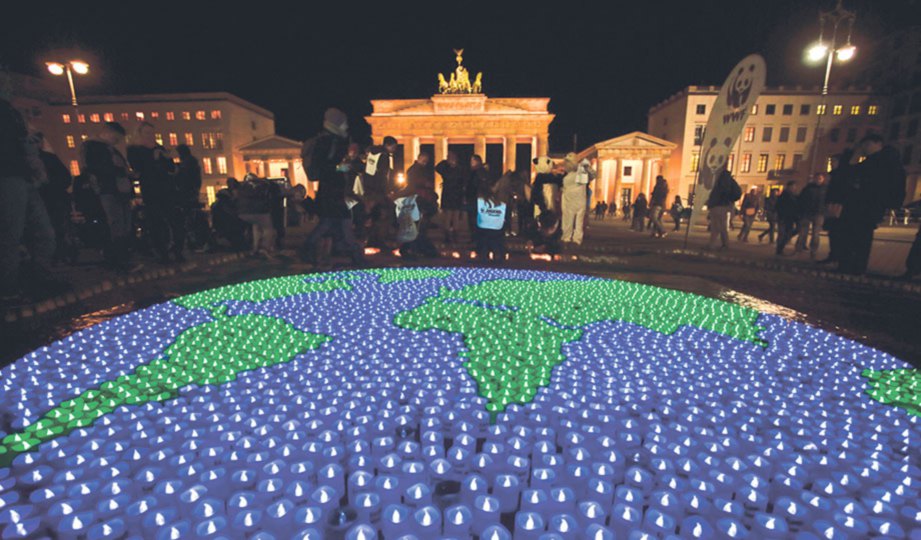 LILIN berwarna hijau dan biru yang disusun berbentuk bumi di Brandenburg Gate, Berlin.