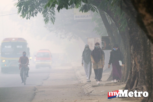 Penduduk Palembang, Indonesia, memakai penutup hidung.