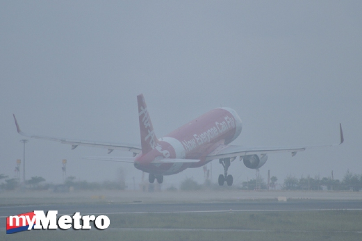 Pesawat AirAsia berlepas dalam keadaan landasan diselubungi jerebu di Lapangan Terbang Antarabangsa Phuket, Thailand, hari ini. - Foto Reuters