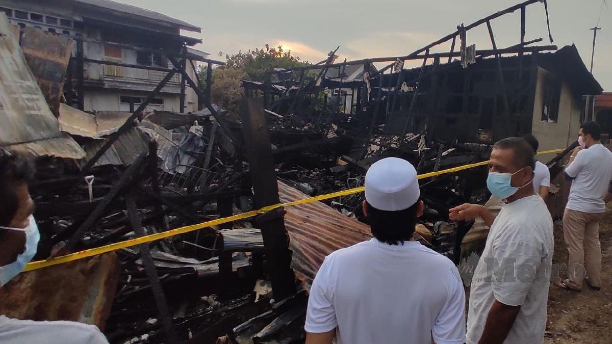 ZAKARIA (kanan) menunjukkan lokasi arwah ibunya ditemui dalam kebakaran di Kampung Losong Haji Su, Kuala Terengganu. FOTO ZAID SALIM