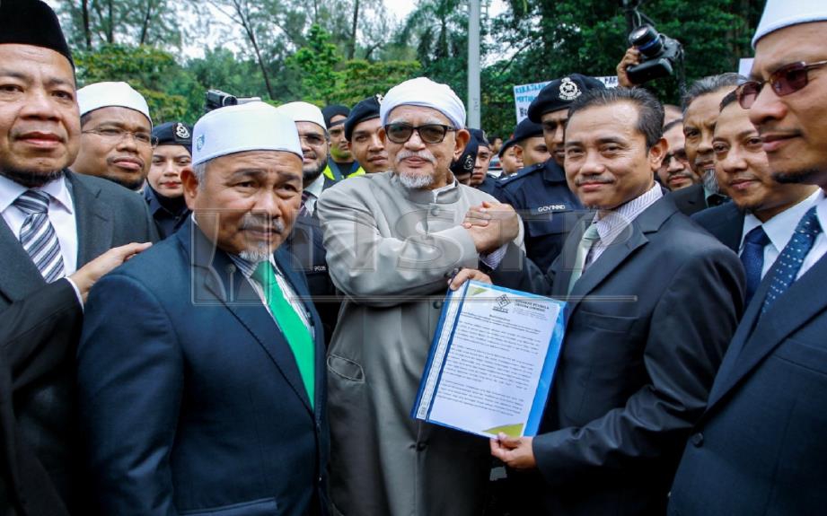 Abdul Hadi menerima memorandum dari Pengerusi Gerakan Pembela Ummah (Ummah), Aminuddin Yahya bagi bantah ICERD sebelum menyerahkan kepada wakil JPM. FOTO Asyraf Hamzah 