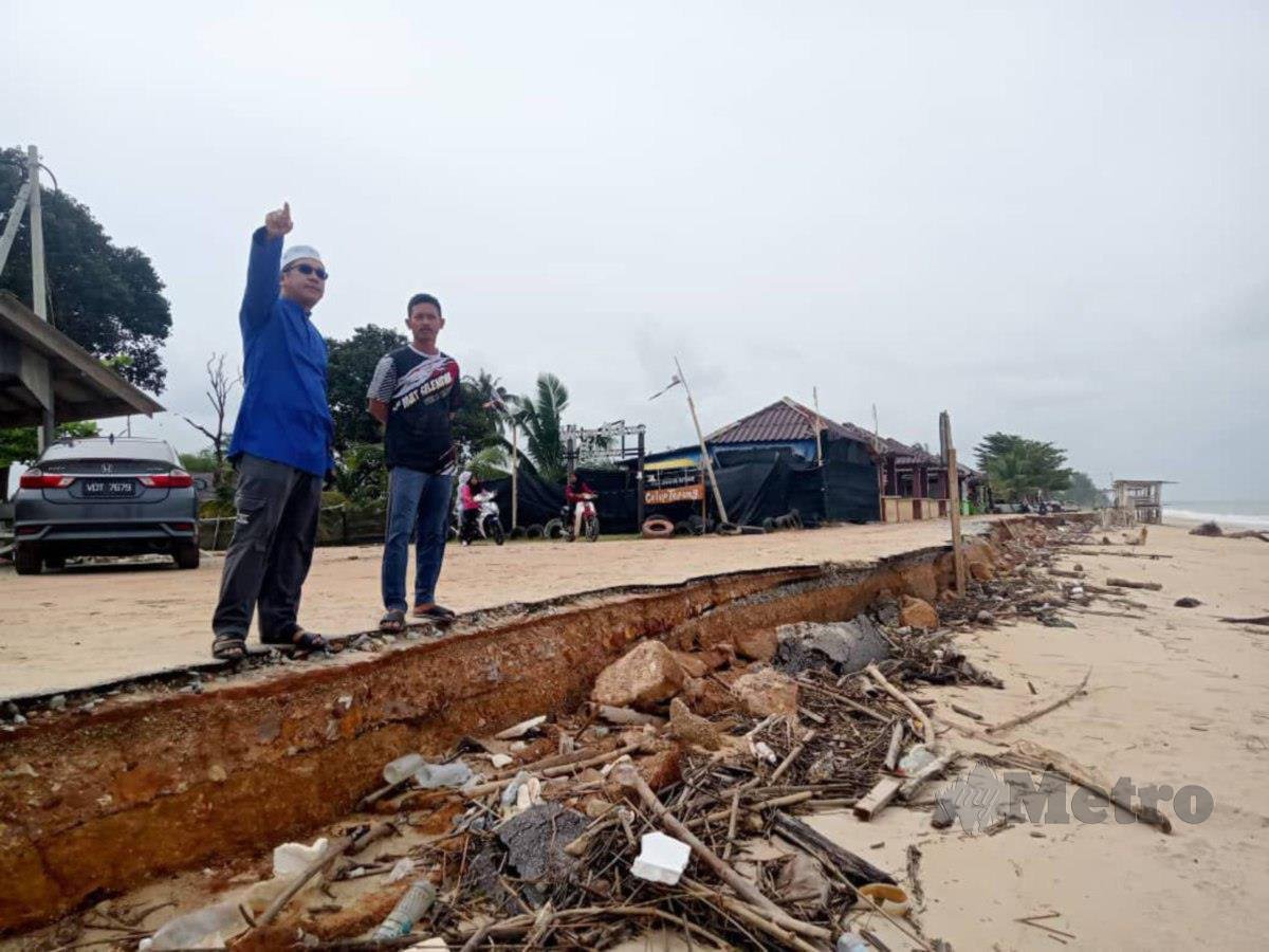 TENGKU Zaihan (kiri) dan Zulkifli meninjau runtuhan tebing di Pantai Kampung Pachakan, Kuala Besut, semalam. FOTO Baharom Bakar