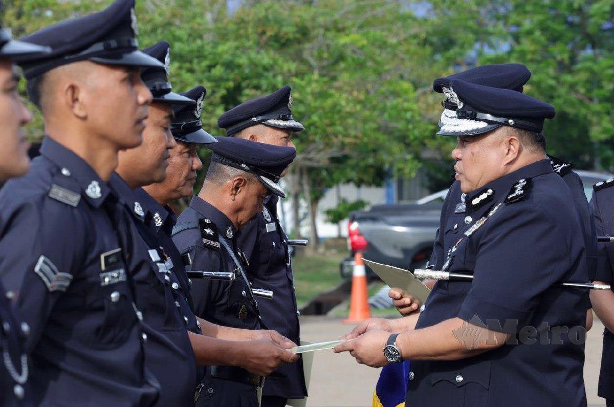 Idris menyerahkan sijil penghargaaan kepada anggota polis pada majlis perhimpunan bulanan IPK Sabah, Kota Kinabalu. FOTO  JUWAN RIDUAN