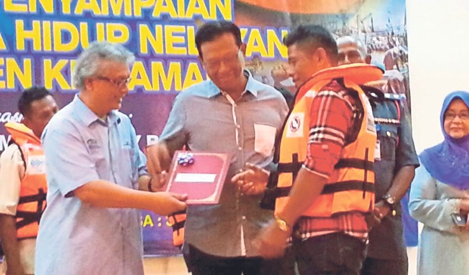 M Saedon (kiri) menyampaikan sijil kepada wakil nelayan kawasan Parlimen Kemaman sambil disaksikan Menteri Pertanian dan Industri Asas Tani Datuk Seri Ahmad Shabery Cheek.